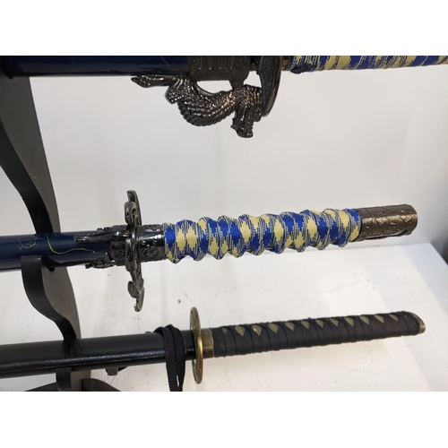 577 - Three blunt Samurai swords to include two with blue sheaths, and another with a black sheath Locatio... 