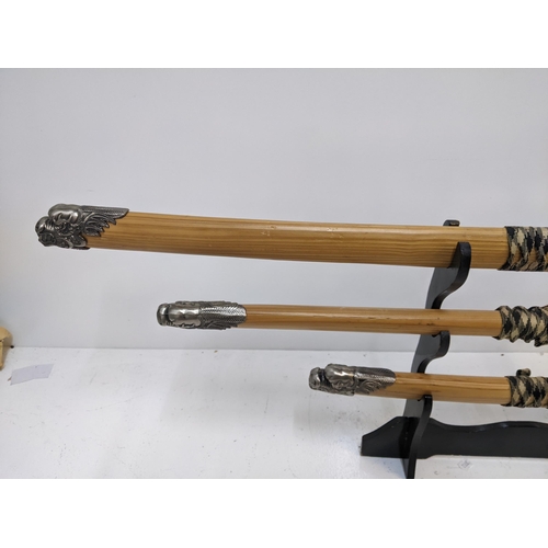 578 - Three blunt Samurai swords, all with caned sheaths with ends fashioned as dragons Location: GM
If th... 