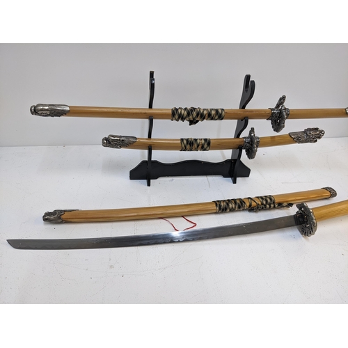 578 - Three blunt Samurai swords, all with caned sheaths with ends fashioned as dragons Location: GM
If th... 