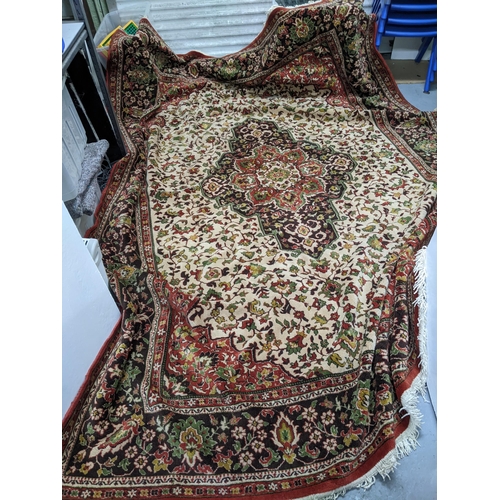 584 - A large machine woven Persian style rug, central medallion surrounded by floral all over decoration ... 