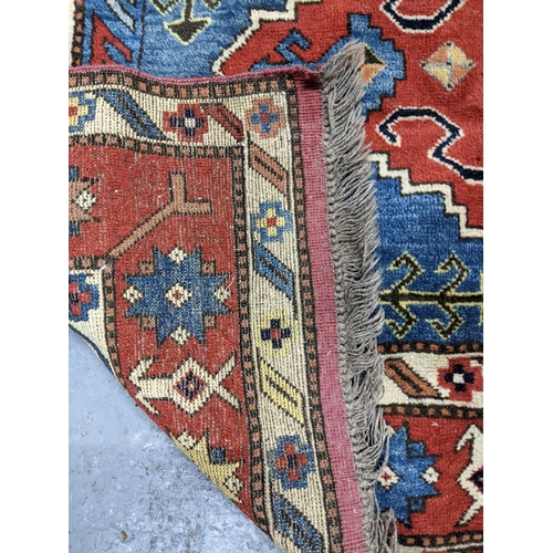 585 - A hand knotted Turkish rug, three central diamond shaped gulls with geometric designed devices, trip... 