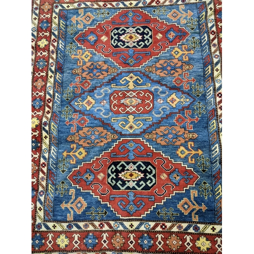 585 - A hand knotted Turkish rug, three central diamond shaped gulls with geometric designed devices, trip... 