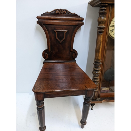 591 - A Victorian mahogany hall chair with an ornately carved back, and a walnut and beech late 19th centu... 