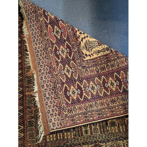 597 - Two Persian rugs to include one with a symmetrical repeating design on a dark blue background and an... 