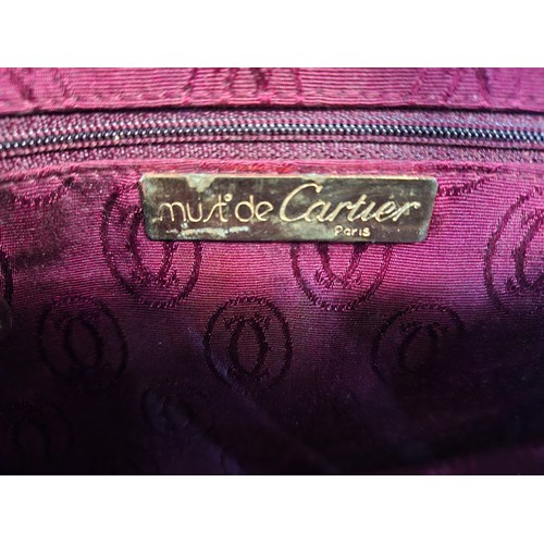 14 - Must de Cartier- A late 20th Century burgundy leather handbag in the bowling bag style having gold t... 