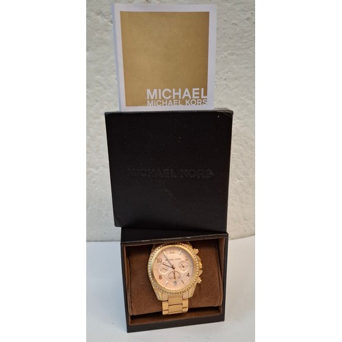 15 - Michael Kors- A ladies over-sized gold tone and white crystal watch with original watch box. Locatio... 