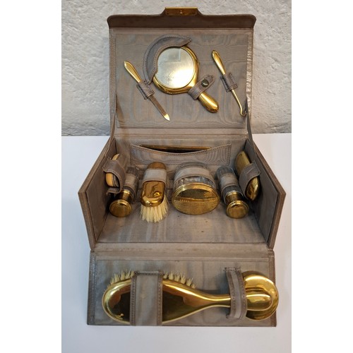 68 - A mid 20th Century vanity set housed in a mid brown leather case enclosing 12 items with gold tone h... 