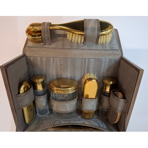 68 - A mid 20th Century vanity set housed in a mid brown leather case enclosing 12 items with gold tone h... 