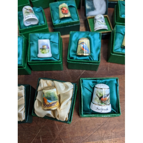 206 - A collection of hand painted enamel and porcelain thimbles, each signed and dated by Graham Payne of... 