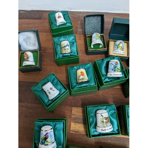 206 - A collection of hand painted enamel and porcelain thimbles, each signed and dated by Graham Payne of... 