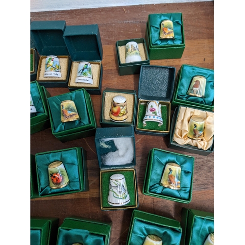 206 - A collection of hand painted enamel and porcelain thimbles, each signed and dated by Graham Payne of... 