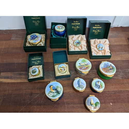 207 - A collection of Graham Payne hand painted and enamelled pill boxes of various sizes, decorated with ... 