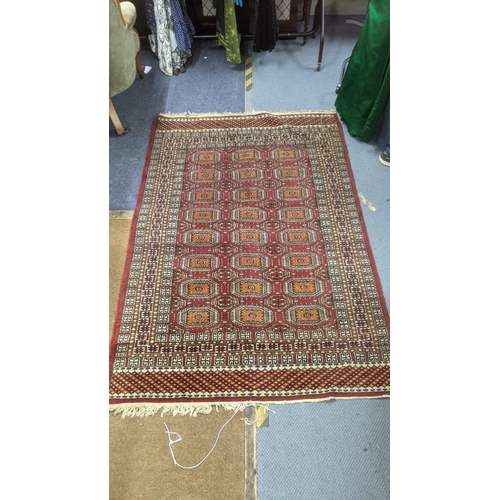 345 - A handwoven Bokha rug on ed ground with repeating motifs and repeating pattern to the centre with ta... 