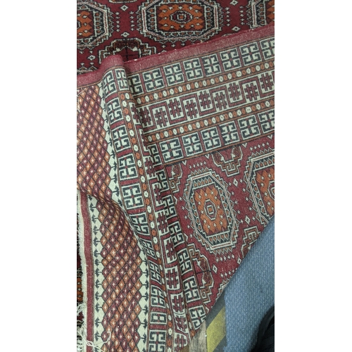 345 - A handwoven Bokha rug on ed ground with repeating motifs and repeating pattern to the centre with ta... 