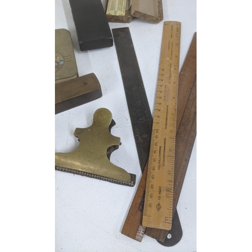 425 - A mixed lot to include a group of vintage tools, a level tube measuring reel, rulers and others toge... 