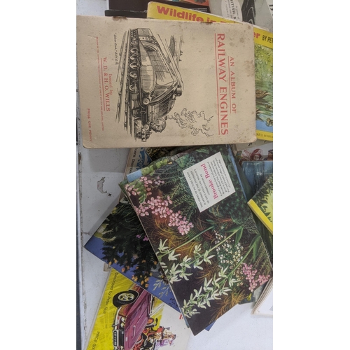 429 - A mixed lot of ephemera to include a collection of mostly filled cigarette card books, with loose ex... 