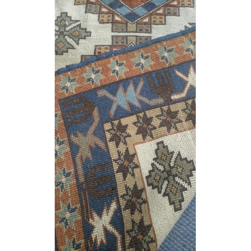 435 - A Turkish hand woven rug having repeating motifs cream ground with multi guard borders and tasselled... 