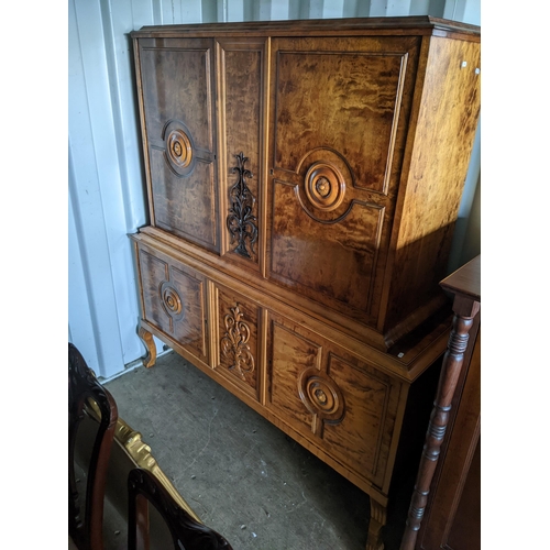 431 - A reproduction Continental cabinet having four cupboard doors with two central scroll carved motifs ... 