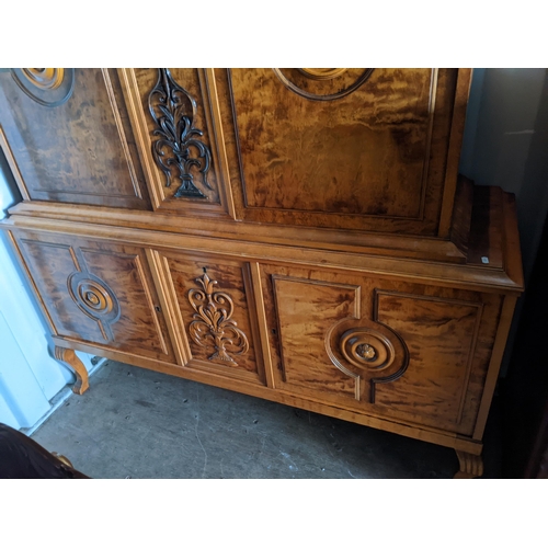 431 - A reproduction Continental cabinet having four cupboard doors with two central scroll carved motifs ... 