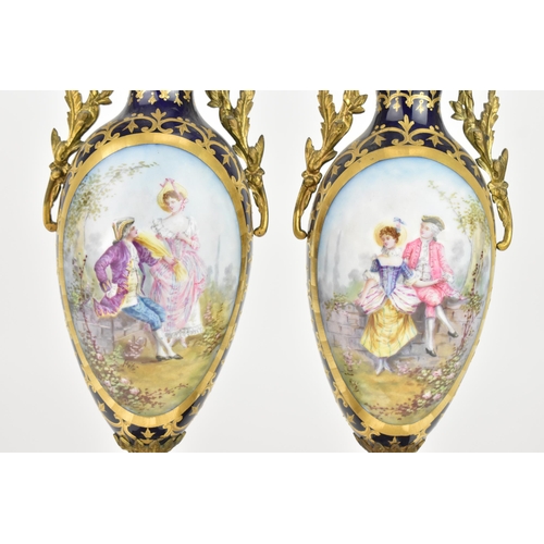 121 - A pair of late 19th century Sevres style lidded vases, each on a dark blue ground with gilded scroll... 