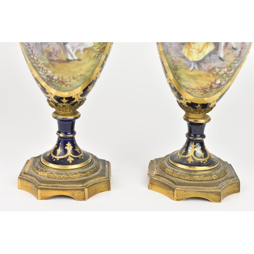 121 - A pair of late 19th century Sevres style lidded vases, each on a dark blue ground with gilded scroll... 