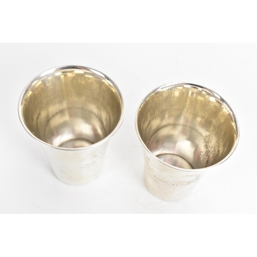 31 - Two 1920s Georg Jensen Danish silver cups, each of tapering form, one engraved with flowers and the ... 