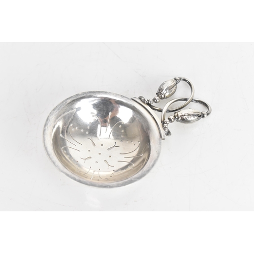 33 - A Georg Jensen Danish Silver Tea-Strainer, import marks for London 1959, No. 84, Blossom pattern, th... 