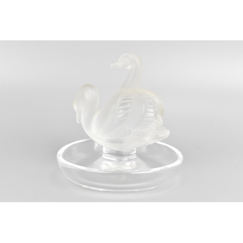 43 - A Lalique glass ring dish, the centre moulded as two frosted swans, the base etched 'Lalique France'... 