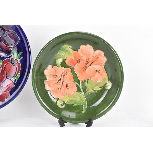 5 - Three Moorcroft pottery plates to include a 'Hibiscus' pattern plate on a green ground measuring 22c... 