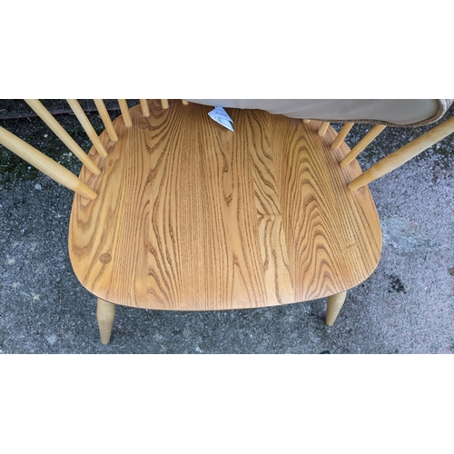 50A - A vintage Ercol light elm and beech 'Swan Back' armchair, with turned legs united by a crinoline str... 