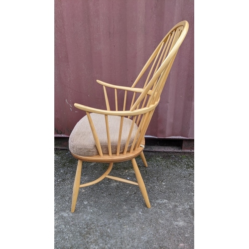 50A - A vintage Ercol light elm and beech 'Swan Back' armchair, with turned legs united by a crinoline str... 