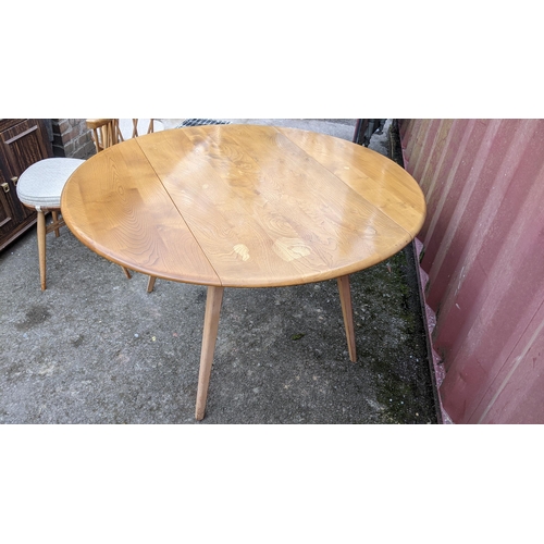 60A - A 1960s Ercol blond elm 'Windsor' model 384 fall flap kitchen table and four model 376 beech and elm... 