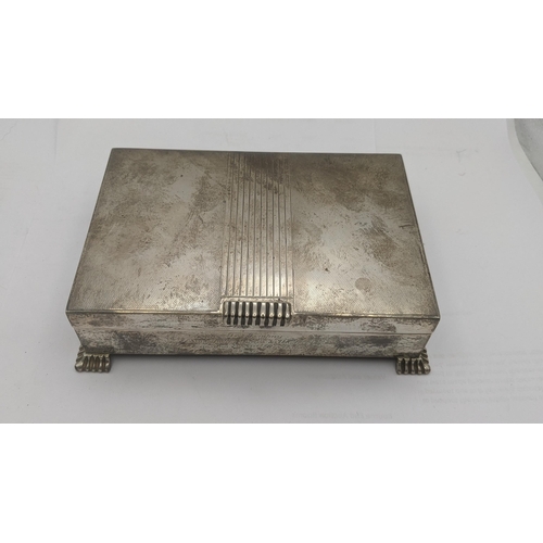 1 - A silver cigarette box having and engine turned lid on four feet with engraved inscription to the fr... 