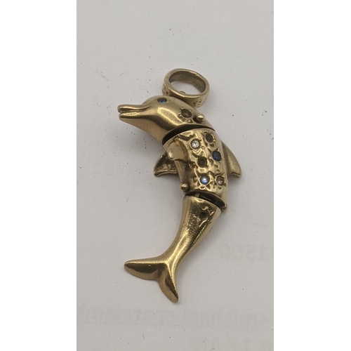 17 - A 9ct yellow gold Dolphin pendant with moving joints set with coloured paste stones 36mm long (some ... 