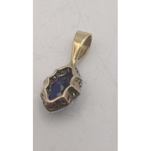 33 - An yellow and white gold pendant set with sapphire coloured stone and diamonds, tested as 18ct gold,... 