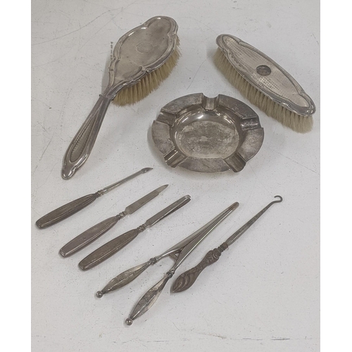 63 - A group of silver to include an ashtray, dressing table items including brushes A/F, silver handled ... 