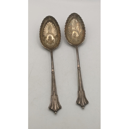 67 - A pair of Victorian silver serving spoons having floral and embossed and engraved bowls hallmarked S... 