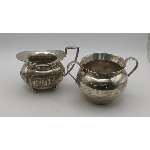 68 - Silver to include a Walker and Hall cream jug on four ball feet together with a twin handled sugar b... 