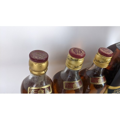 265 - Four bottles of Johnnie Walker whisky to include an Extra Special Black label 12 years with original... 