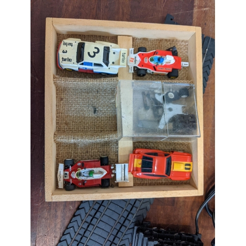 21 - An Aurora World Championship Motor Racing set with two remote controllers, four cars, track, and pla... 