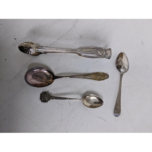 111 - A group of silver flatware to include Victorian sugar nips, Georgian shell back spoon with engraved ... 