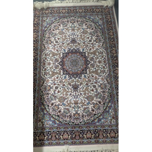 38 - A Persian machine woven rug on cream ground with floral multicoloured design, with central motif and... 