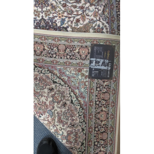 38 - A Persian machine woven rug on cream ground with floral multicoloured design, with central motif and... 