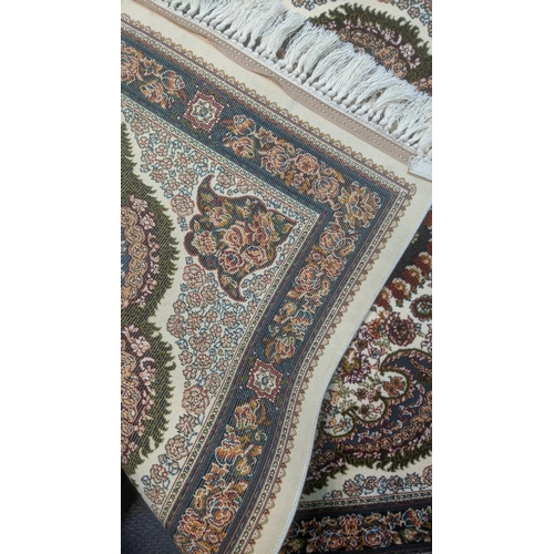 40 - A pair of Persian machine woven rugs on cream ground with central motifs and floral borders with tas... 