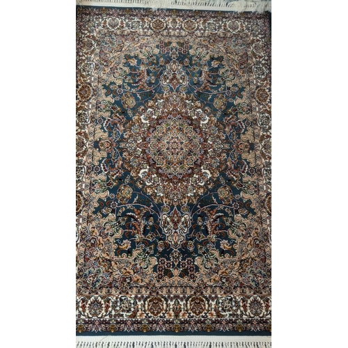 45 - A Persian machine woven rug on green ground with floral central motif and floral repeating border wi... 