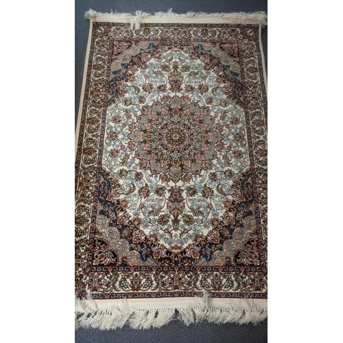 55 - A Persian machine woven rug on cream ground with central motifs, repeating borders on a floral groun... 