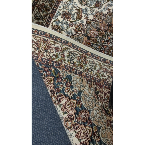 65 - A Persian machine woven rug on cm ground with floral central motifs and floral boarders, with tassel... 