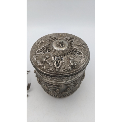 71 - A late 19th/early 20th century white metal Burmese cylindrical box with pierced decoration and the b... 