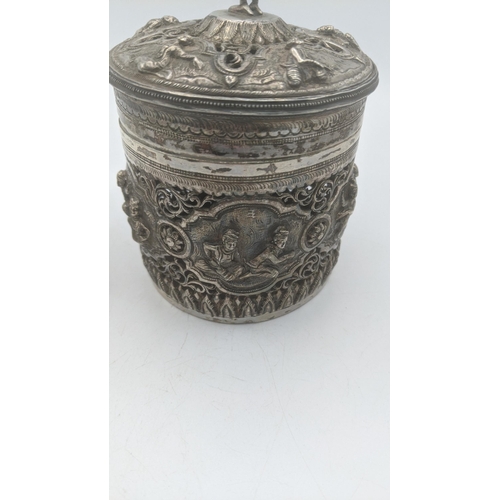 71 - A late 19th/early 20th century white metal Burmese cylindrical box with pierced decoration and the b... 