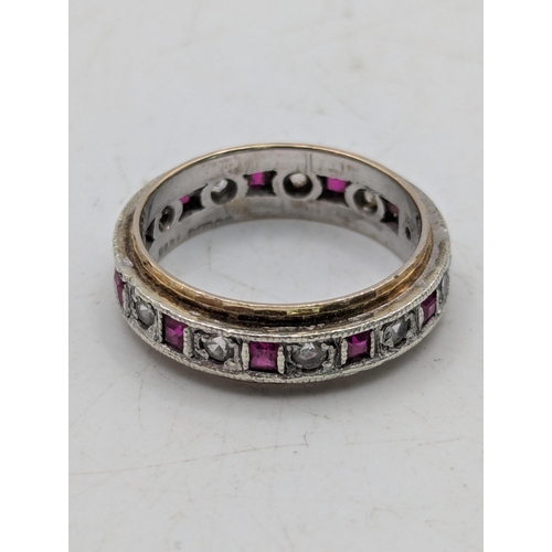 75 - A 9ct white and yellow gold eternity ring, Channel set with rubies and white spinel, size O 4.5g Loc... 
